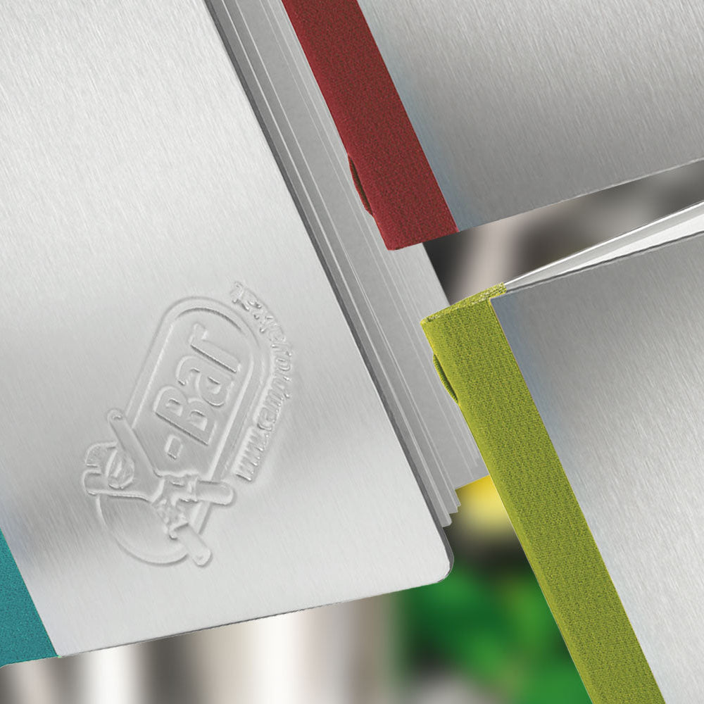 Detailaufnahme mehrerer Speisekarten aus Aluminium mit Blindprägung und farbigem Buchrücken aus Buchleinen in verschiedenen Farben