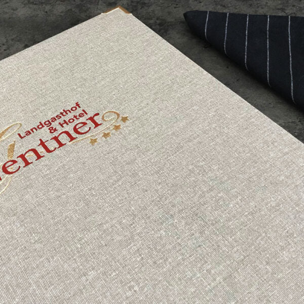 Detailaufnahme einer Speisekarte aus Buchleinen mit farbigem Stick auf der Vorderseite