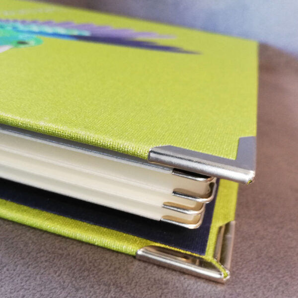 Detailaufnahme einer Speisekarte aus Buchleinen in der Farbe Kiwi mit Metallecken