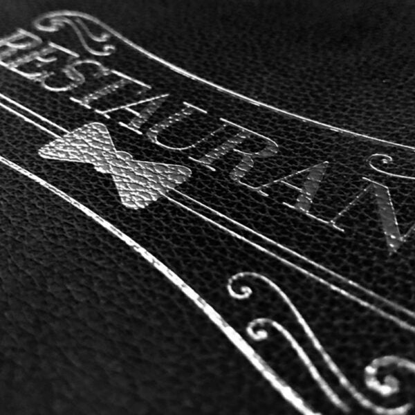Detailaufnahme einer silbernen Veredelung auf einer Speisekarte aus Designleder in der Farbe schwarz