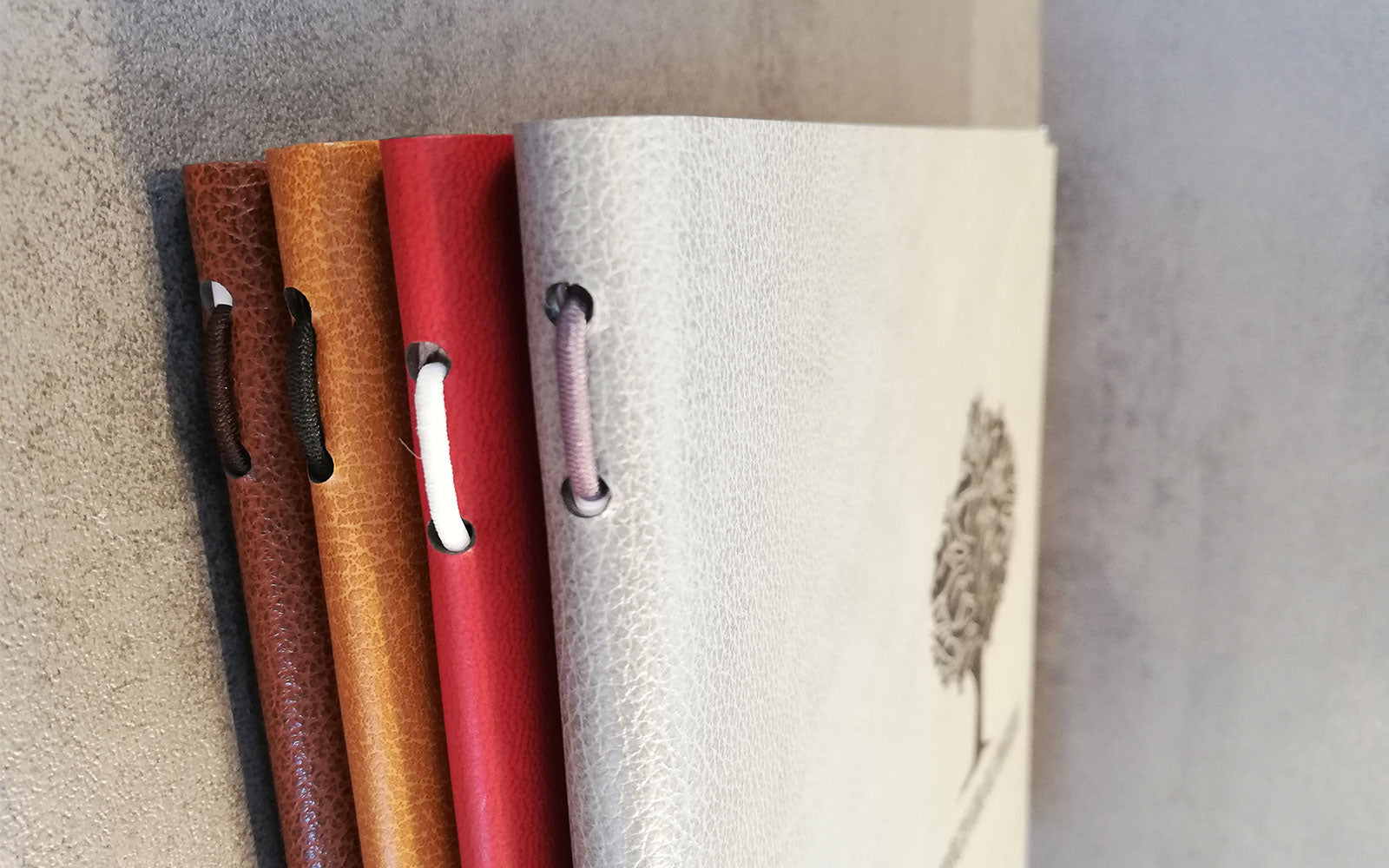 Detailaufnahme von Speisekarten aus recyceltem Leder in verschiedenen Farben mit Splitkordel-Funktion