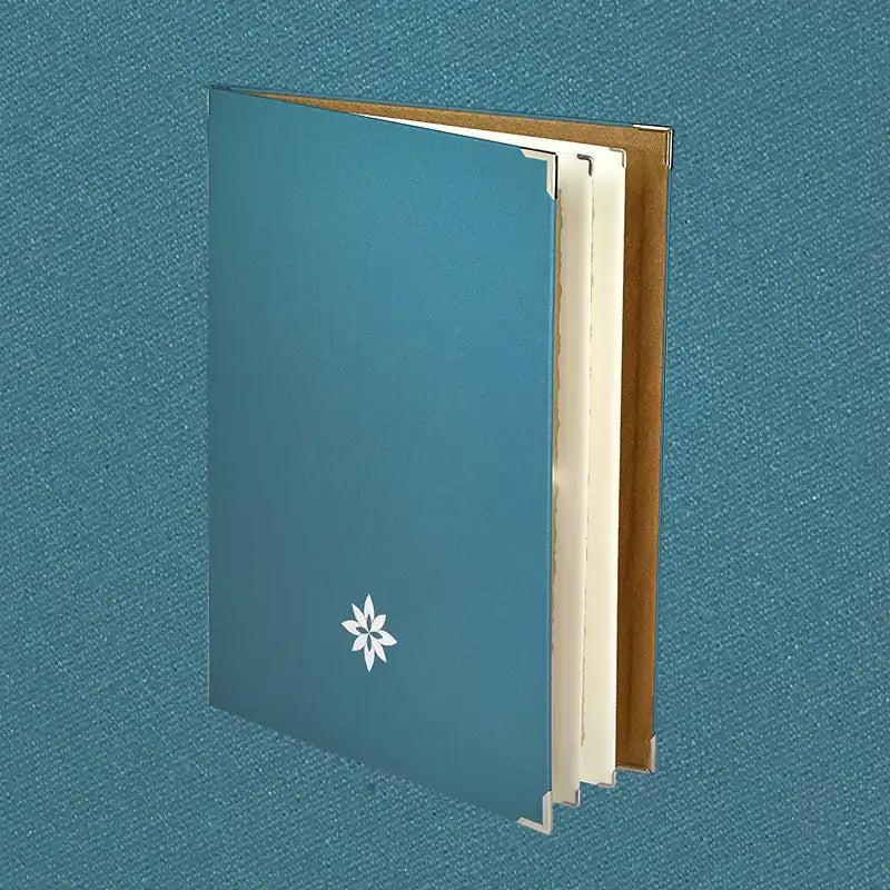 Speisekarte aus Buchleinen in der Farbe Petrol mit Metallecken und dezenter weißer Veredelung