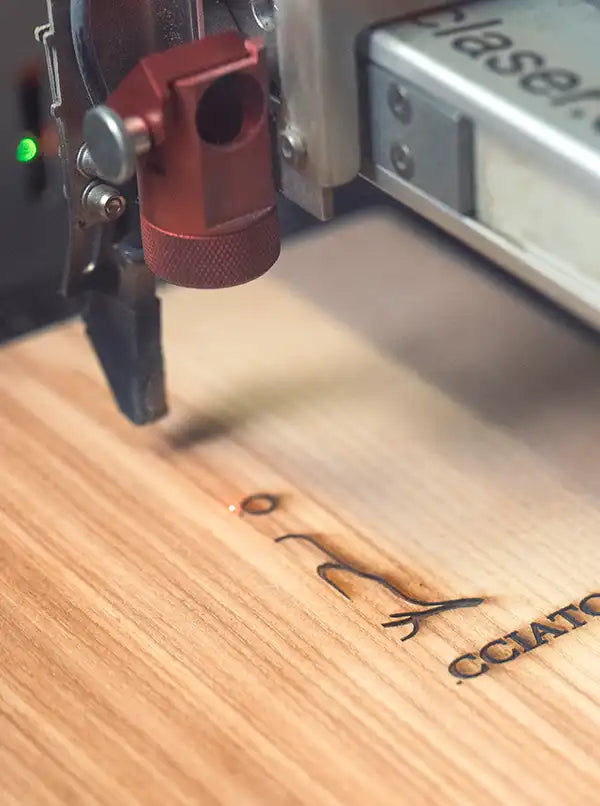 Lasergravur eines Logos auf einer Holzspeisekarte in der Reischl Speisekarten Manufaktur